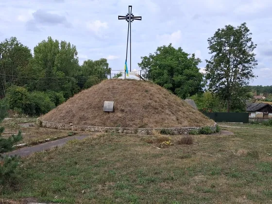 Насипана могила з хрестом посеред села